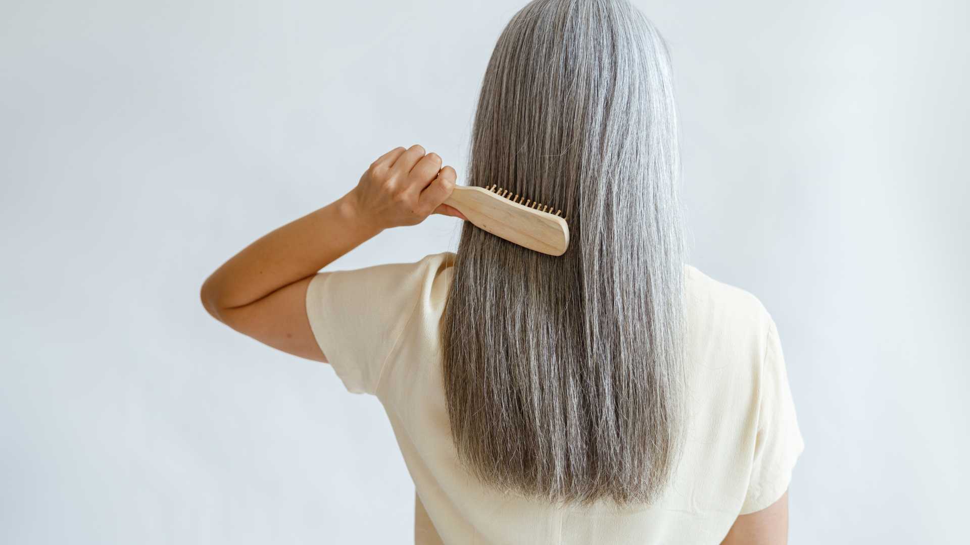 femme qui brosse ses cheveux gris